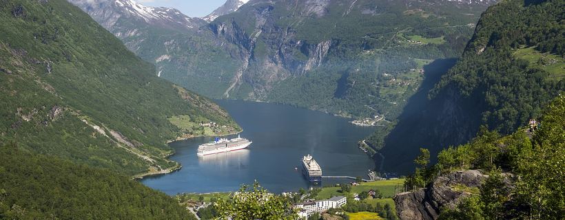 Small cruise ship navigating a Norwegian fjord